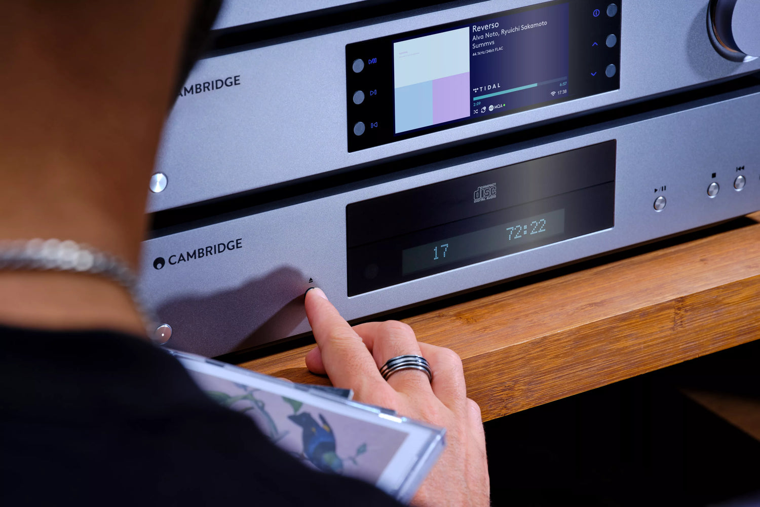 A person using Cambridge Audio CXN100 Network Streaming Player in their home.