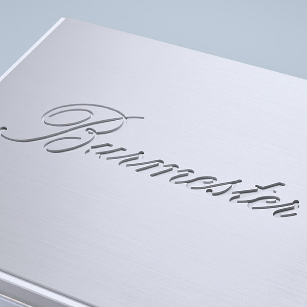 A closeup of a logo of a silver Burmester 111 Reference Line Music Center - HiFi Centre.