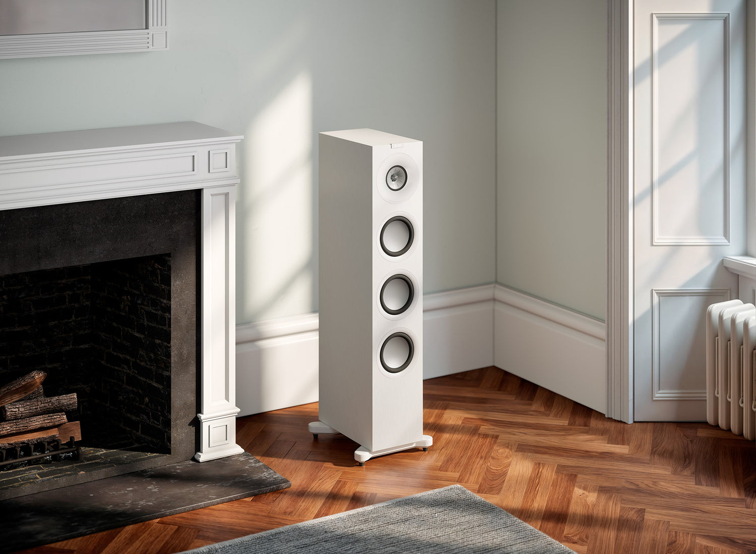 A KEF Q11 Meta HiFi floor-standing speaker in white color in a modern living room.
