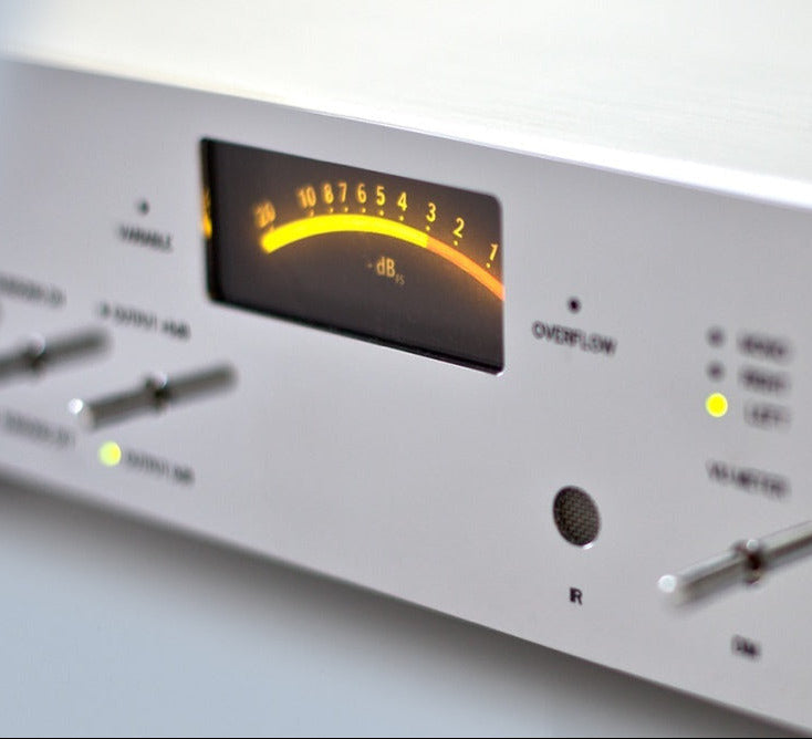 A detailed view of switches of a silver Burmester 100 Top Line Phono Preamplifier with a classic chrome front panel, visible toggle switches, and a VU meter - HiFi Centre.