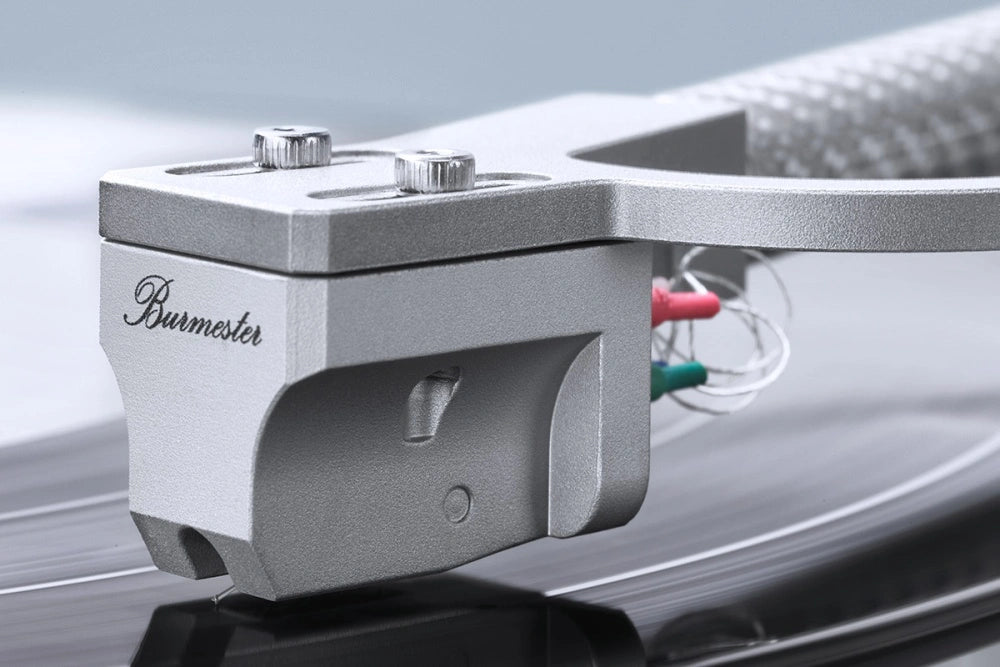 Close-up of a Burmester 175 Reference Line Turntable cartridge on a reflective surface with a blurred background.