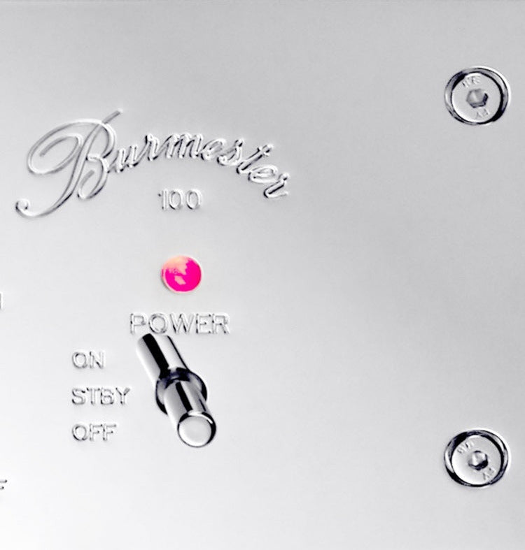 A detail of a logo of a silver Burmester 100 Top Line Phono Preamplifier with a classic chrome front panel, visible toggle switches, and a VU meter - HiFi Centre.