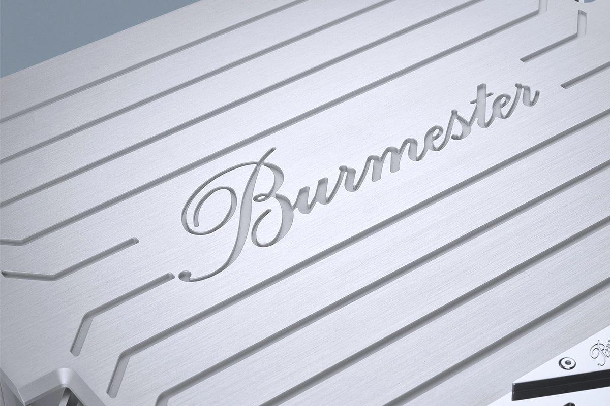 A closeup on a Burmester logo on a silver Burmester 909 Reference Line Power Amplifier - HiFi Centre.