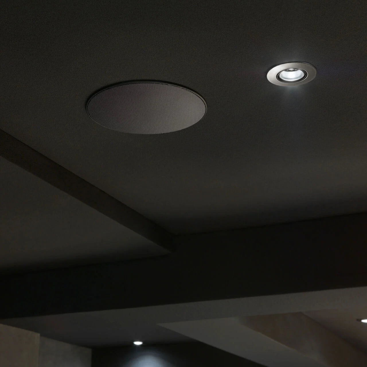 A closeup on a B&W CCM664SR In-Ceiling Speaker installed on a ceiling