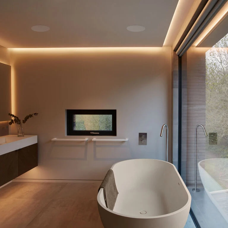 A pair of B&W CCM7.5S2 in-Ceiling Speakers in a modern bathroom with a freestanding tub.