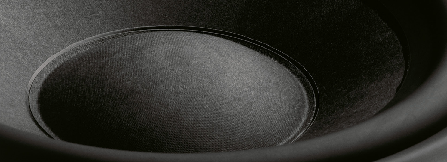Close-up of a black B&W CTSW15 Custom Theatre Passive Subwoofer with a focus on texture and shape.