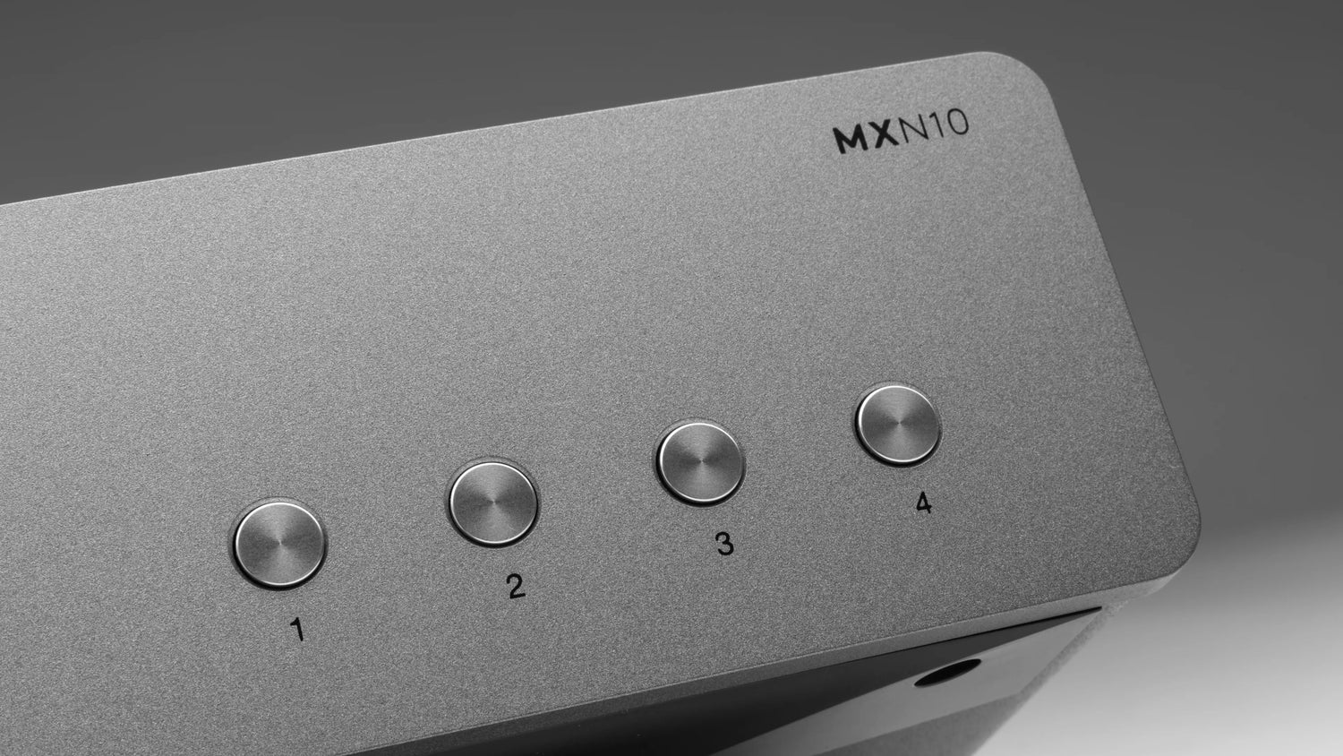 Gray Cambridge Audio MXN10 Compact Network Player with labeled buttons on a gray background - HiFi Centre.