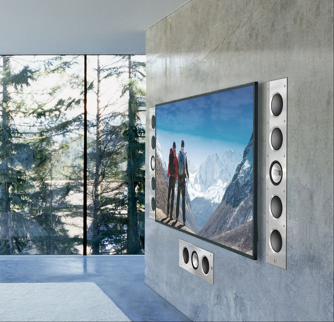 Modern living room with a large TV featuring the KEF Ci200RR-THX displaying a mountain scene, surrounded by large windows with a forest view.