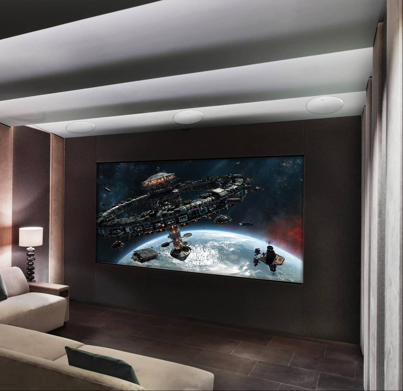 Modern home theater with a large screen displaying an outer space scene, with KEF Ci250RRM-THX Extreme In-Ceiling
speakers installed, surrounded by comfortable seating.