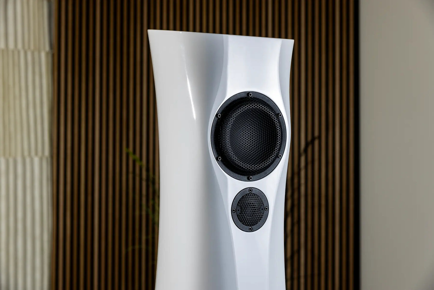 White Liquid Gloss Estelon XB MK II reference speakers with a curved-sculptural design with black components on a textured wall background