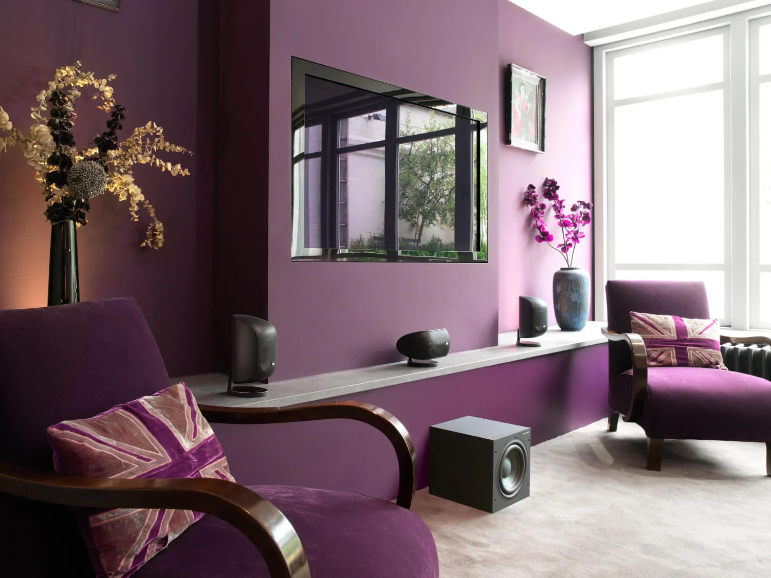 Modern living room featuring home theatre with B&W ASW610 10” Subwoofer, purple walls, furniture, and decor.