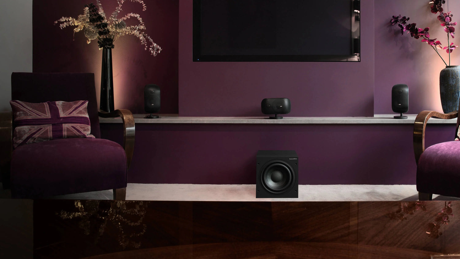 Home theater system with speakers and a B&W ASW608 8” Subwoofer in a room with purple walls and decorative elements.