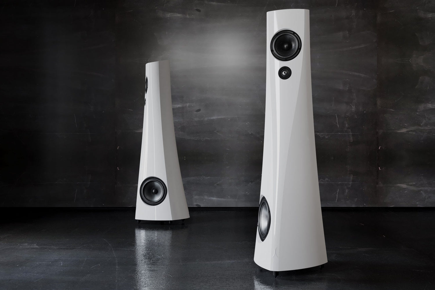 A pair of white gloss Estelon YB MK II Reference Speakers in a dark room.