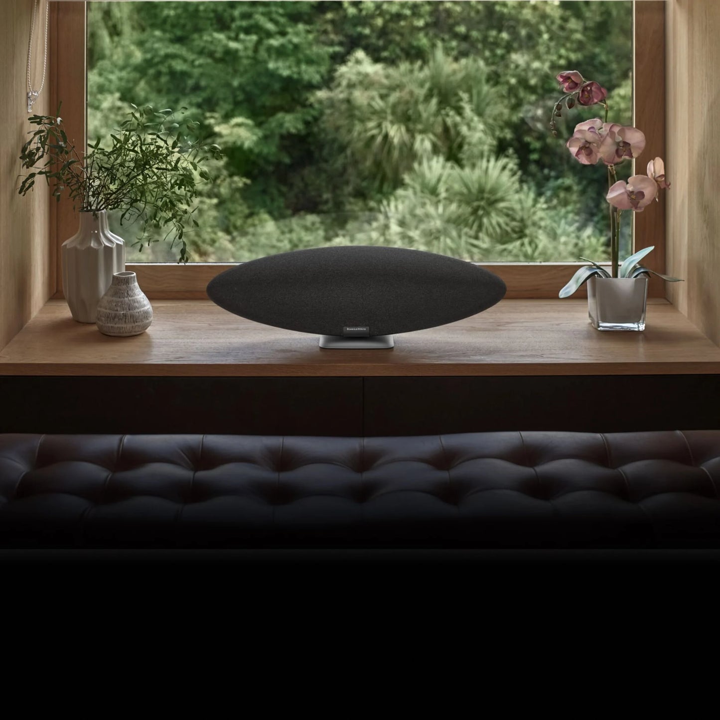 Bowers & Wilkins Zeppelin Pro Wireless Speaker in space grey on a windowsill in a modern living room.