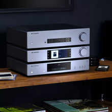 Stack of Cambridge audio equipment including Cambridge Audio CXC V2 CD Transport in a modern living room.