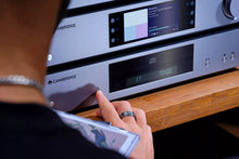 A person using Cambridge Audio CXN100 Network Streaming Player in their home.