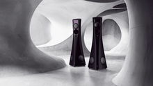 Two black Estelon Forza Reference Speakers  in a futuristic, abstract architectural setting.