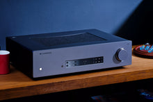 Cambridge Audio CXA81 MKII Integrated Amplifier on a wooden surface with a blue wall background