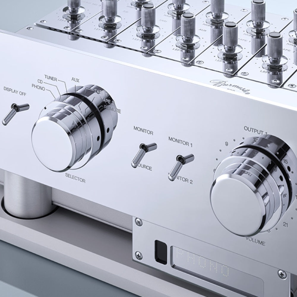 A closeup view of a silver Burmester 808 MK 5 Reference Line Preamplifier with multiple knobs and switches on the front panel, set on a chrome stand - Hi-Fi Centre.