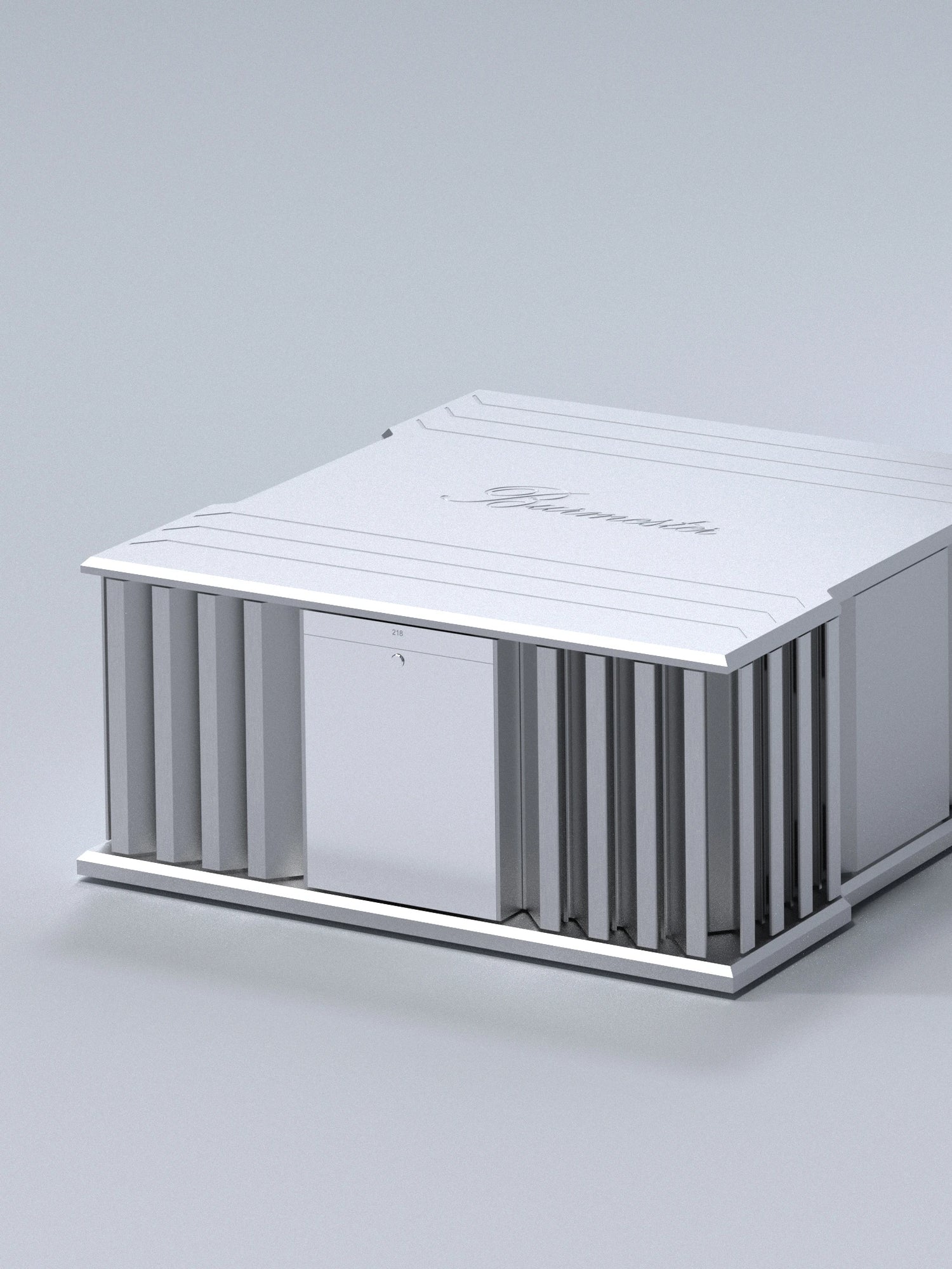 A side side of a silver Burmester 218 Reference Line power amplifier with cooling fins and ports on a gray surface - HiFi Centre.