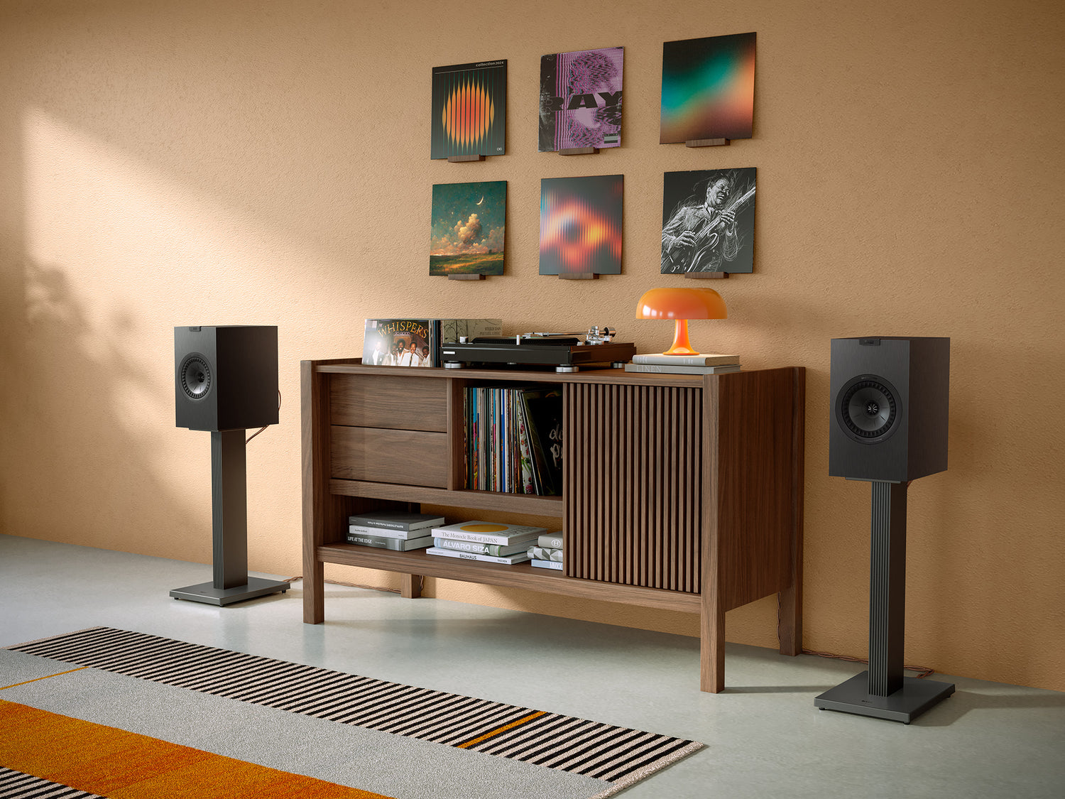 A pair of black KEF Q3 Meta Bookshelf Speakers on stands in a modern living room.