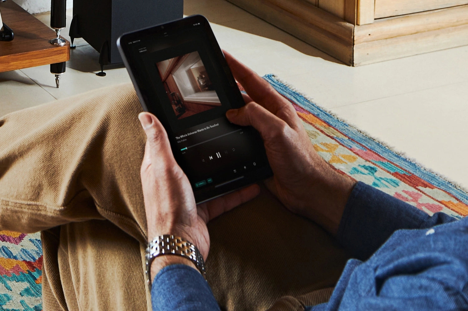 A person controlling Cambridge Audio MXN10 Compact Network Player via app on their phone.