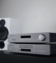 Audio Cambridge Audio AXC35 CD Player and amplifiers on a dark surface with a light gray background.