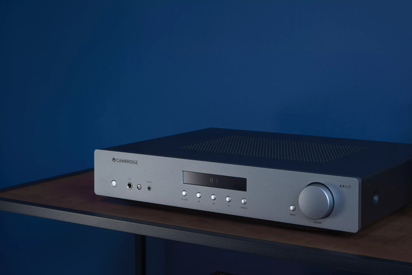 Cambridge Audio AXA35 Integrated Amplifier on a wooden surface with a blue background