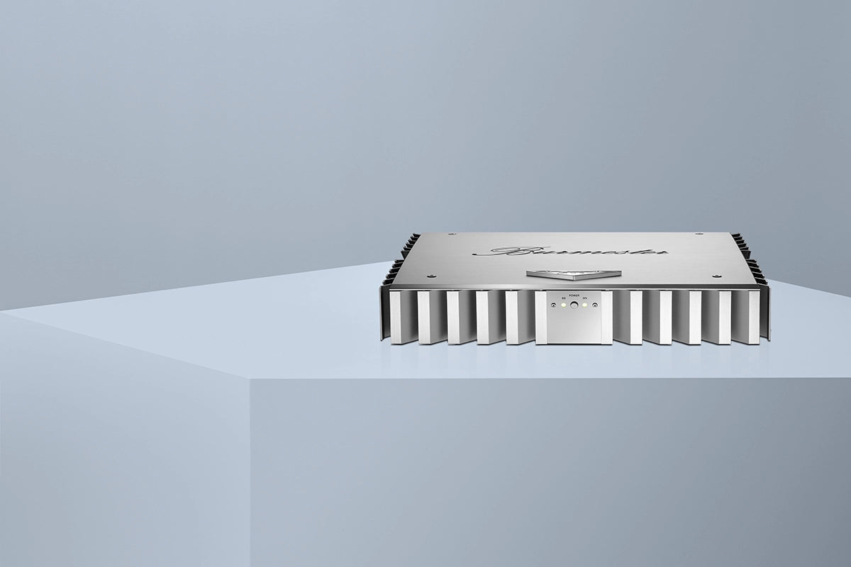 Burmester 036 Classic Line Power Amplifier with silver-anodized aluminum cooling fins and a solid aluminum lid on a blue table - Hi-Fi Centre.