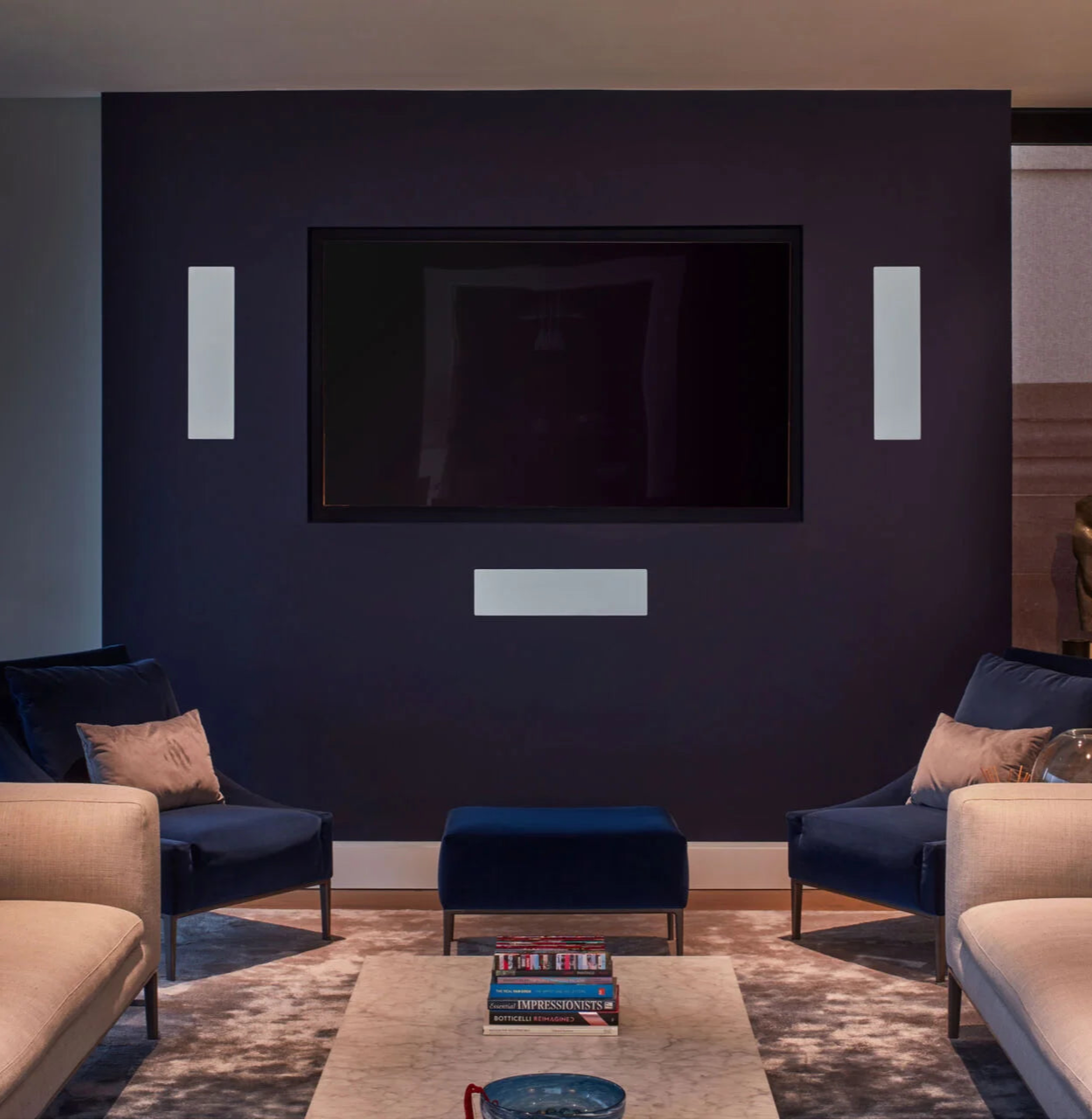 Some B&W CWM8.3D Reference In-Wall Speakers in a modern living room around a in-wall TV.