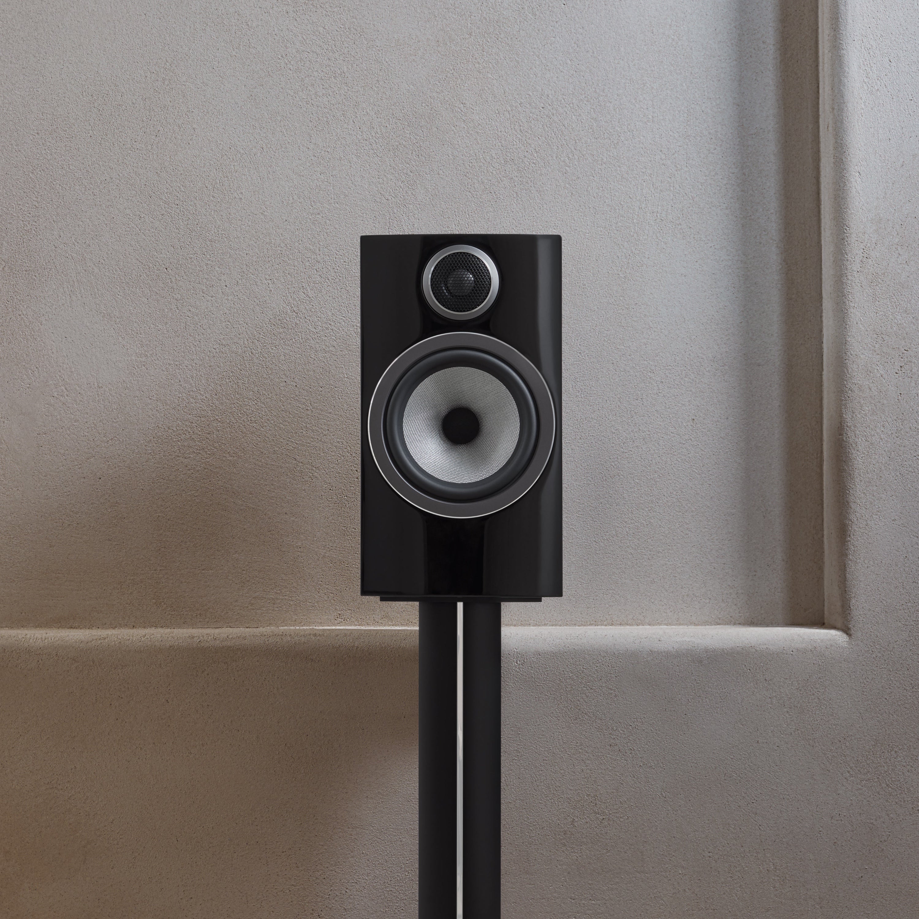 A closeup of B&W 706 S3 Bookshelf Speaker in glossy black finish.