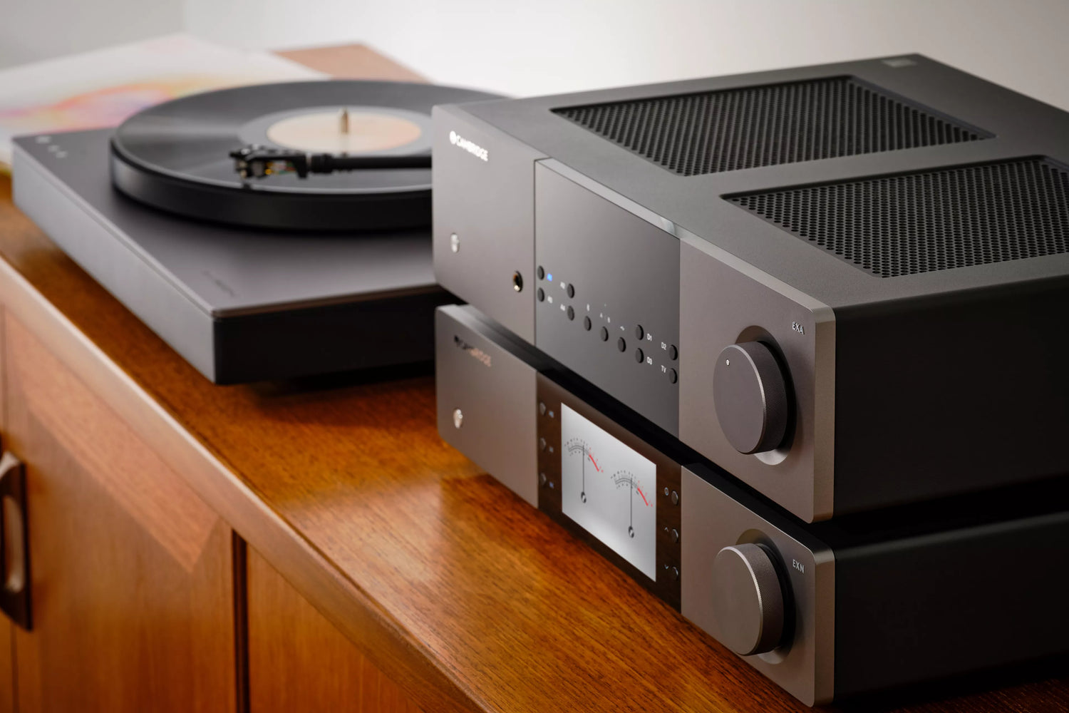 Cambridge Audio EXA100 Integrated Amplifier and a turntable and amplifier on a wooden surface.