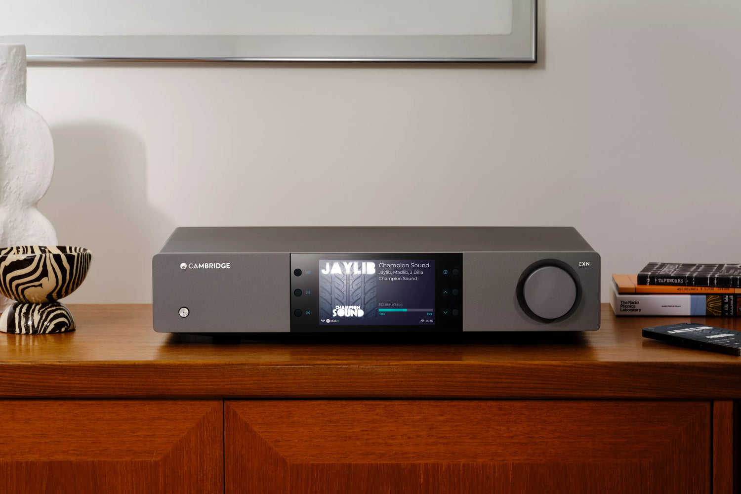 Cambridge Audio EXN100 Network Player on a wooden surface in a modern living room.
