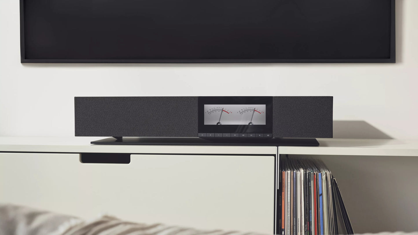 Soundbar on a shelf with a television in the background