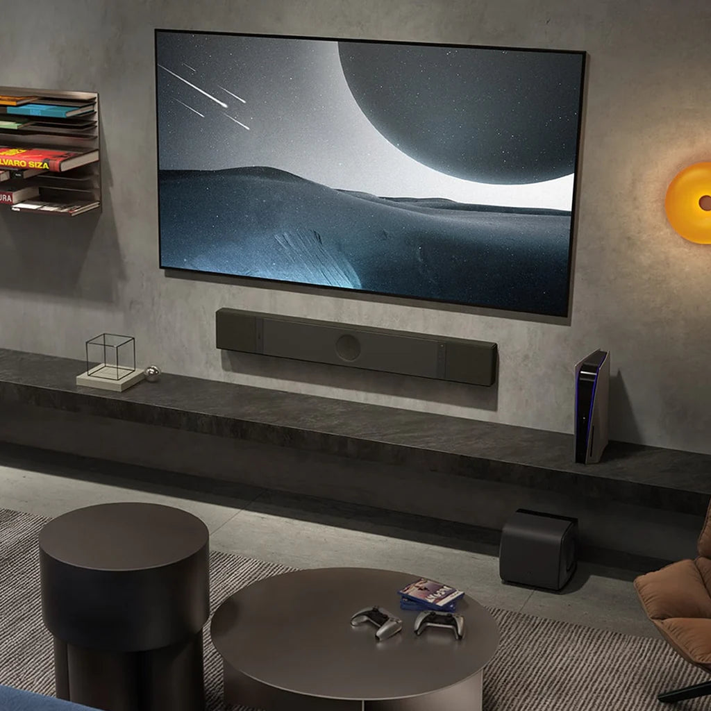 Modern living room with a large TV displaying a space scene, KEF XIO Sound Bar, and gaming console.