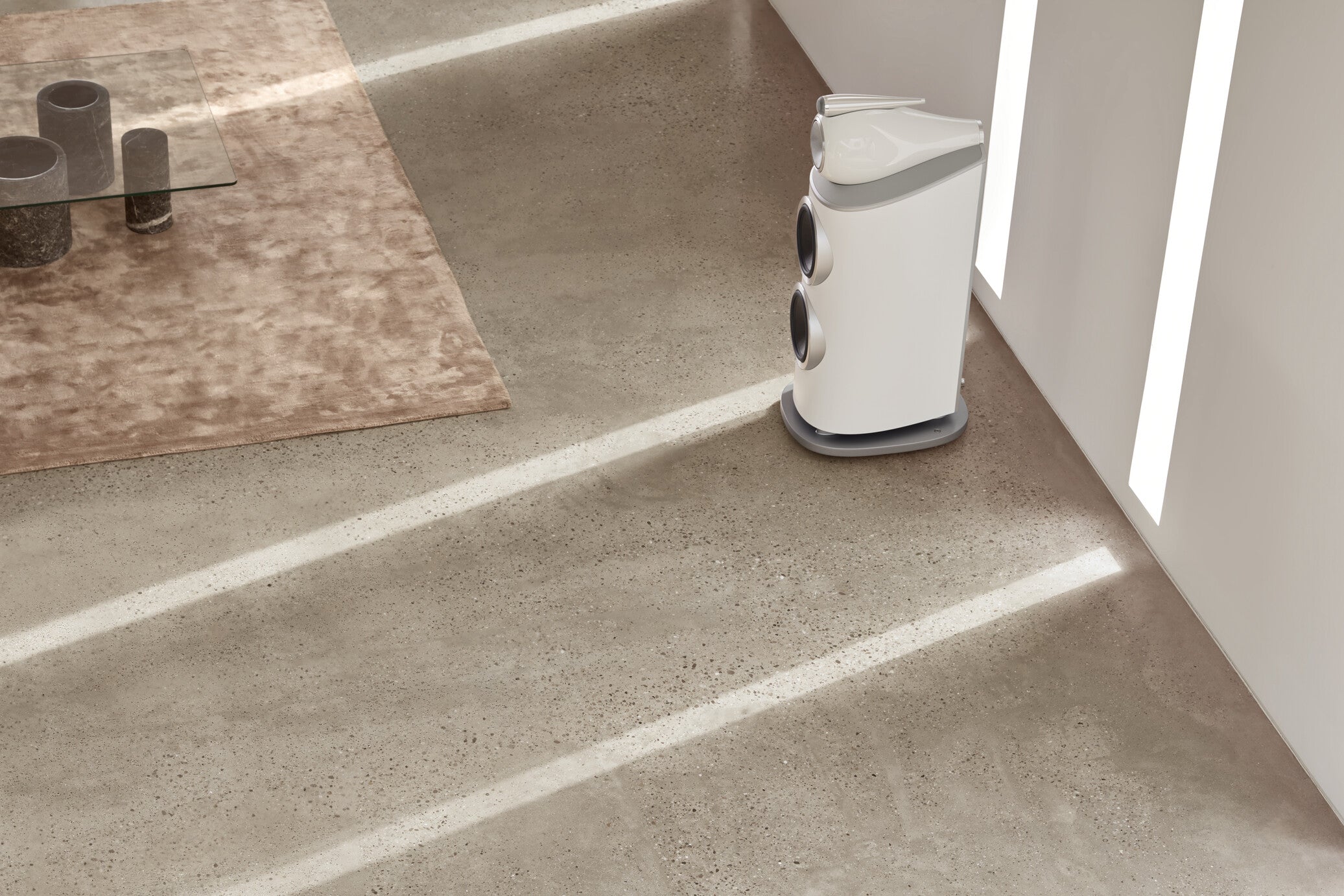 A focus on a B&W 801 D4 Reference Speaker in satin white finish placed on the floor of a modern living room.