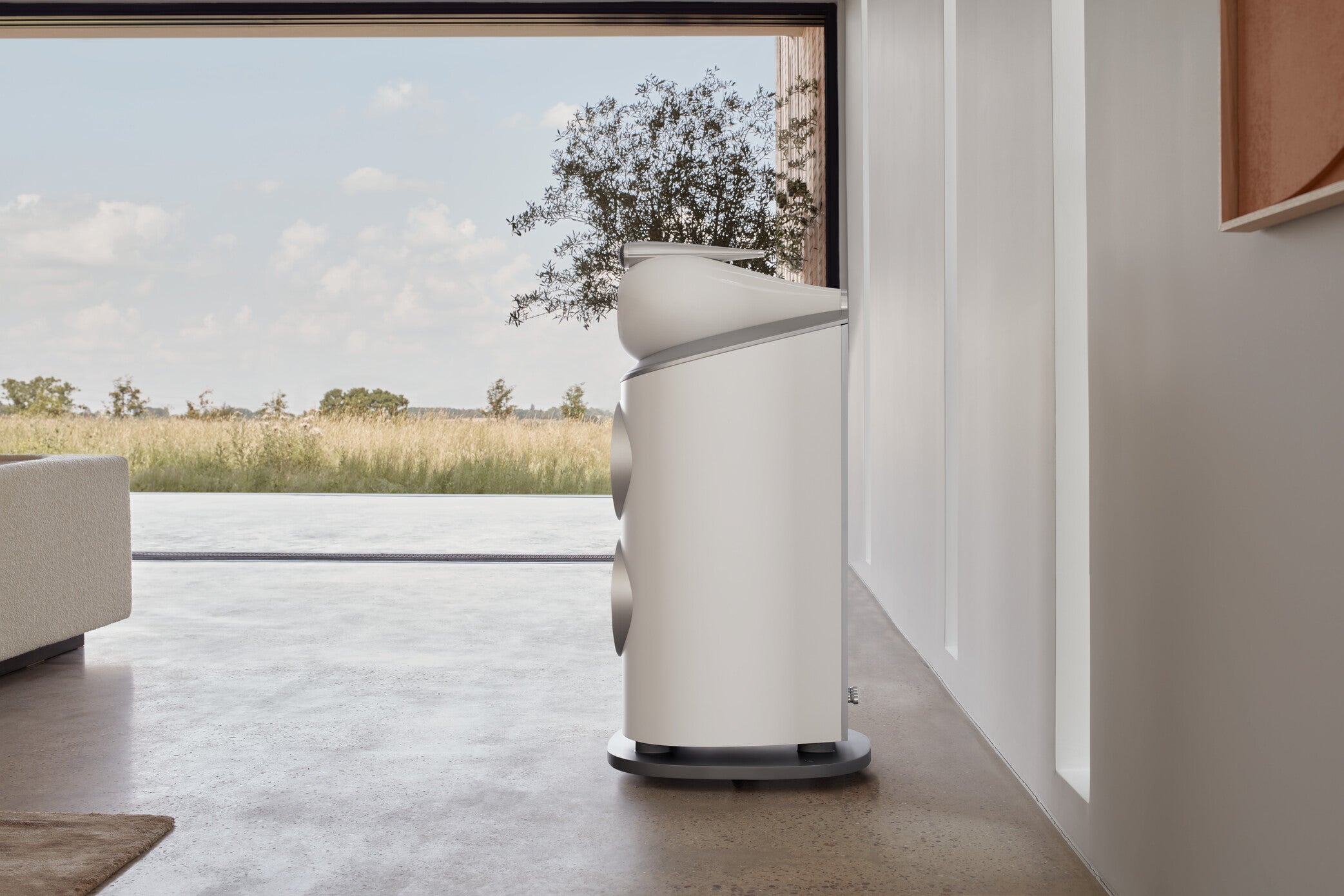A focus on a B&W 801 D4 Reference Speaker in satin white finish placed on the floor of a modern living room.