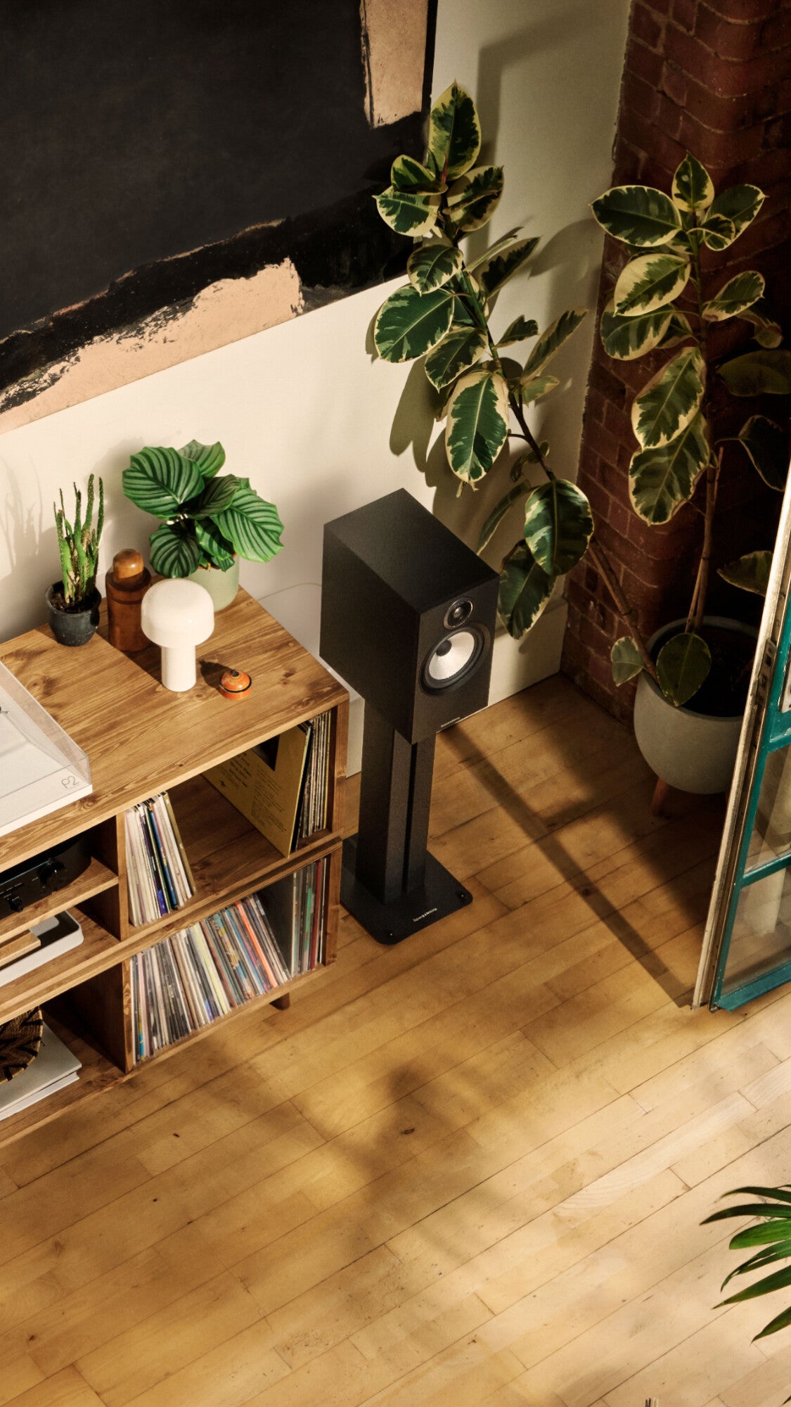 B&W 606 S3 Bookshelf Speaker in black finish in a modern loft living room.