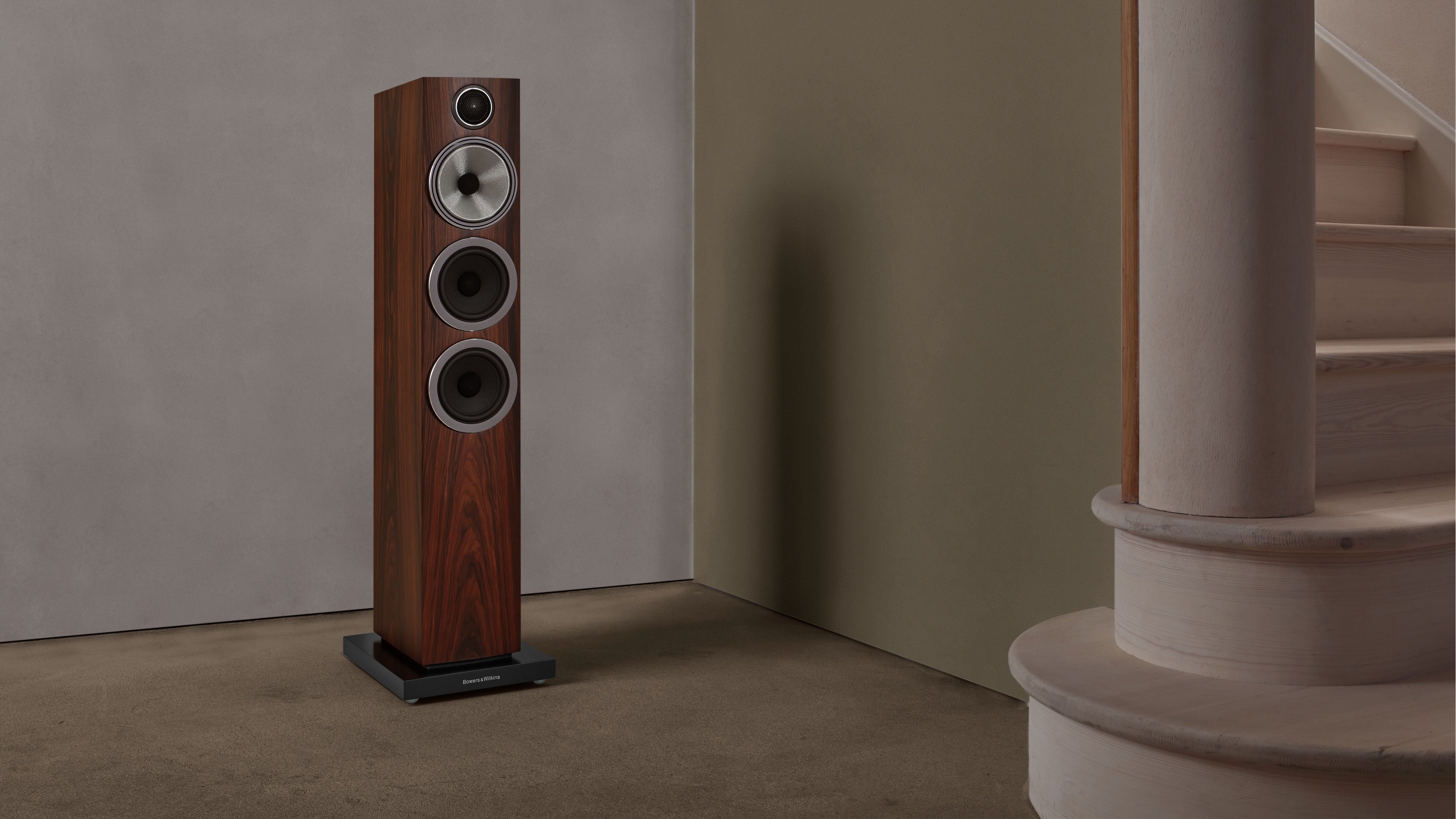 A B&W 704 S3 Floor Standing Speaker in mocha finish in a living room.