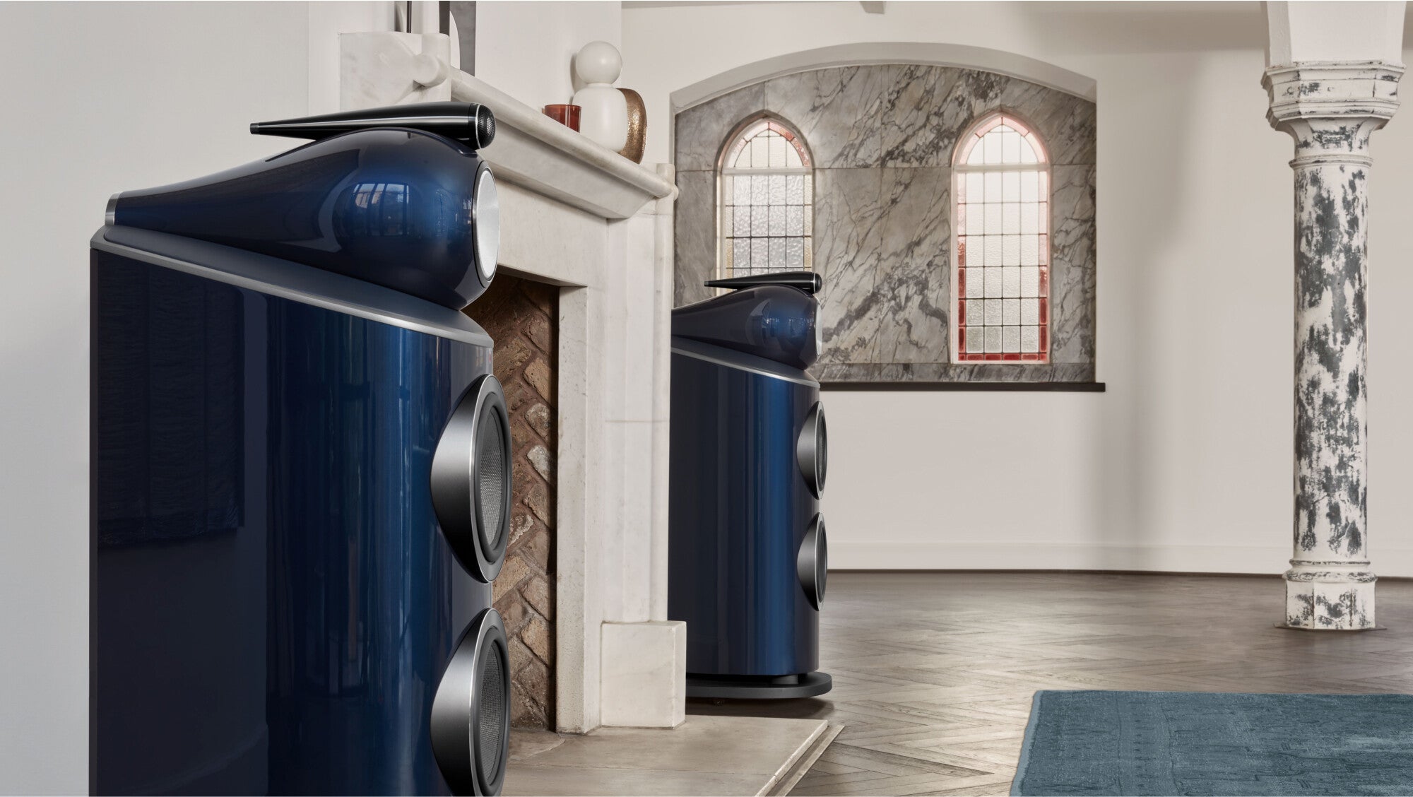 A closeup on a top of a B&W 801 Signature Reference Speaker in midnight blue metallic color finish in a upscale living room.