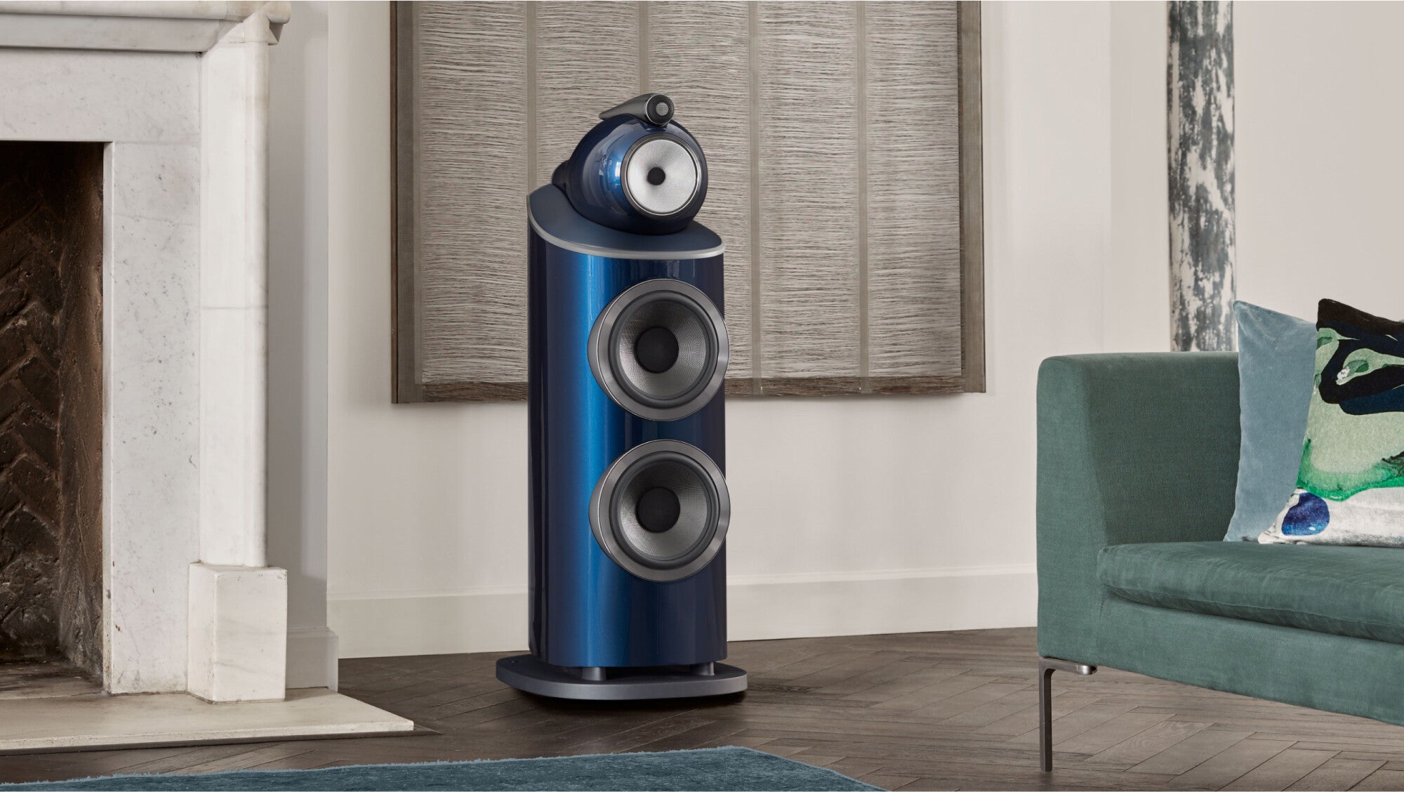 A B&W 801 Signature Reference Speaker in midnight blue metallic color finish next to a fireplace in a modern living room.
