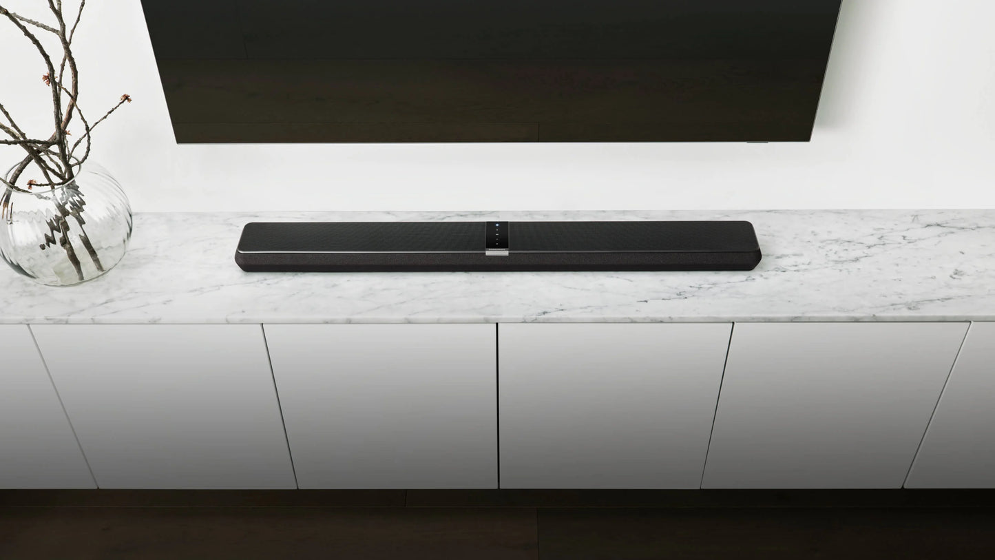 Black B&W Panorama 3 Sound Bar on a white entertainment console with a TV above