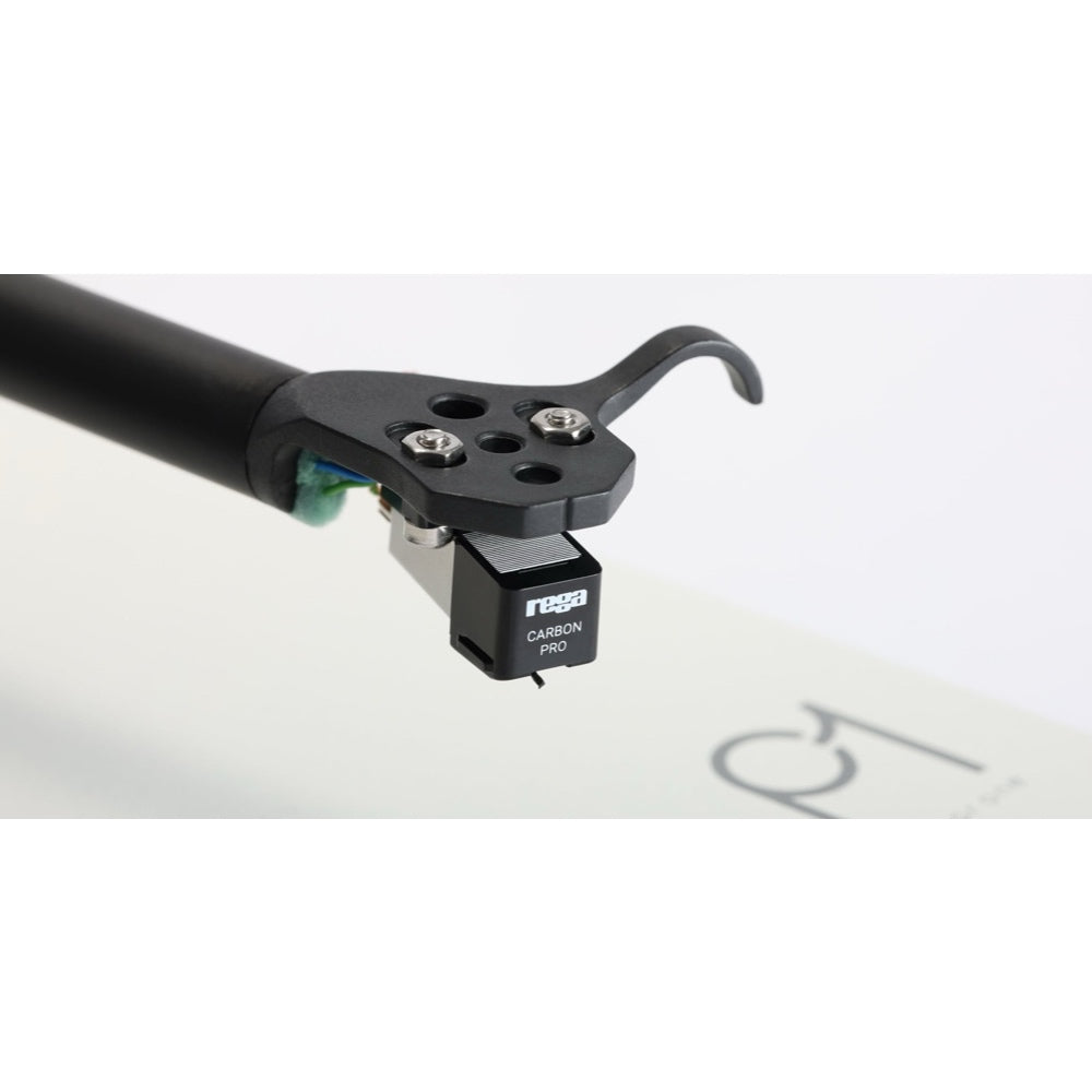 Rega Carbon Pro stylus mounted on black tonearm with white turntable surface background.