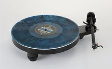 Rega Replay turntable with a blue marbled platter, black tonearm, and low-profile base for home audio systems.