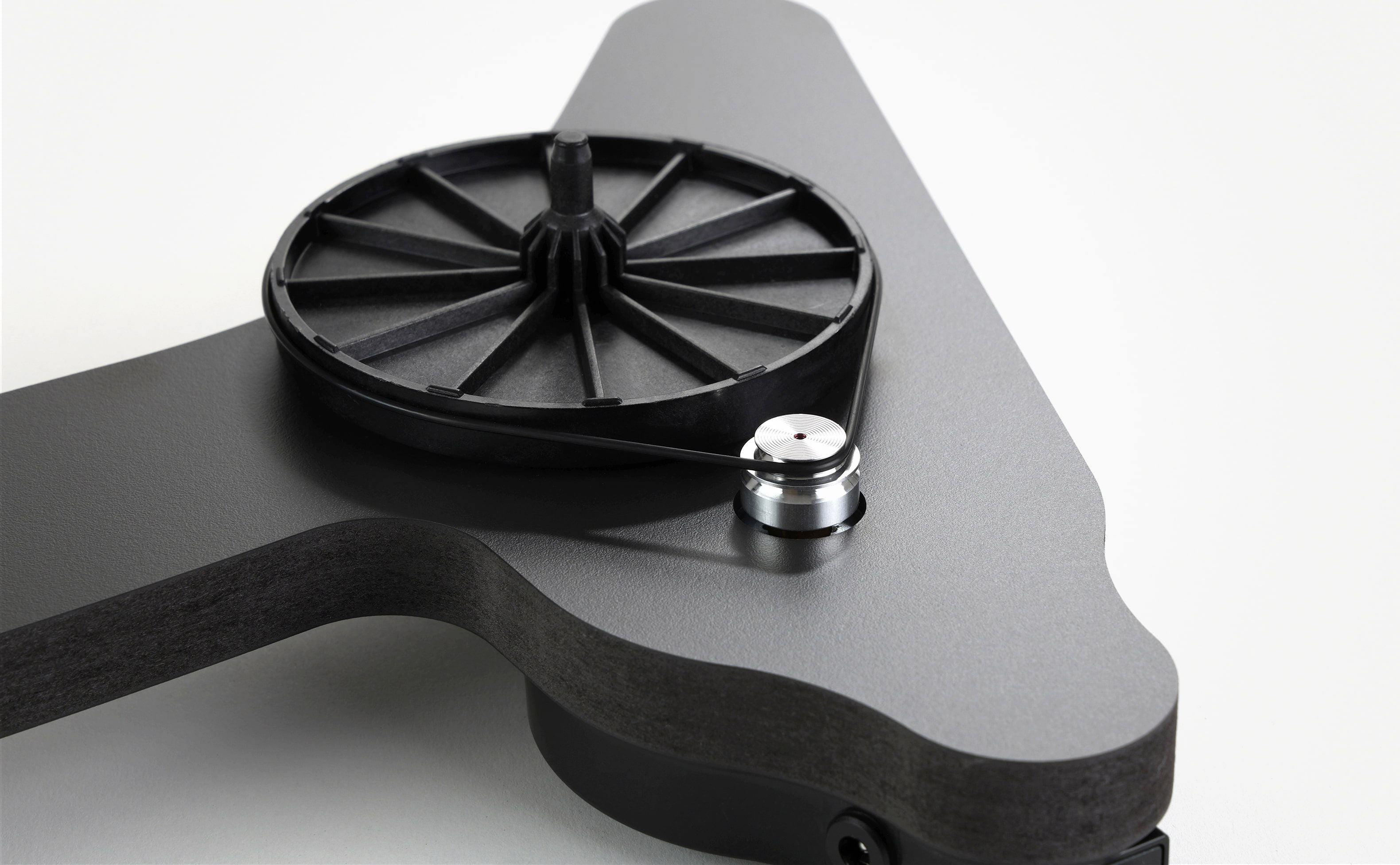Black Rega turntable platter and tonearm on a sculpted charcoal plinth, designed for home audio systems.