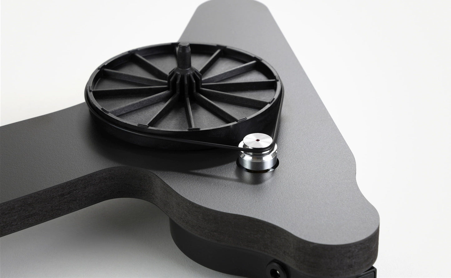 Black Rega turntable platter and tonearm on a sculpted charcoal plinth, designed for home audio systems.