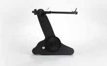 Black Rega turntable tonearm and cartridge assembly on a sculpted base for home audio systems.