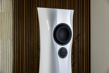 White  Liquid Gloss Estelon XB MK II reference speakers with a curved-sculptural design with black components on a textured wall background