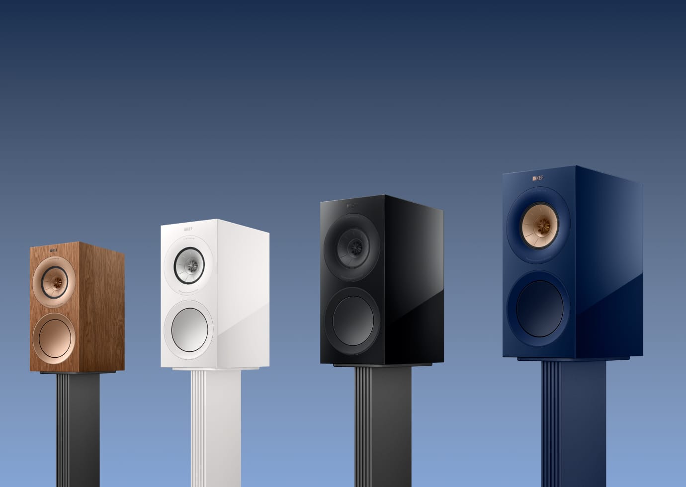 Four speakers of different colors (wooden, white, black, blue) on KEF S3 Floor Stand for R3 against a gradient blue background.
