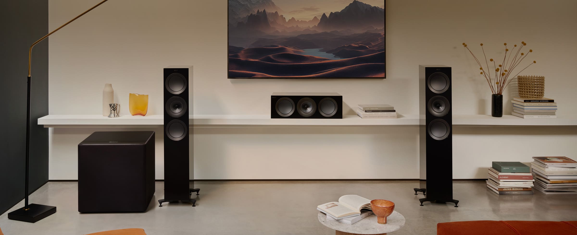 Home theater system with black KEF KUBE 15 MIE 15" Subwoofer and a TV in a living room setting.